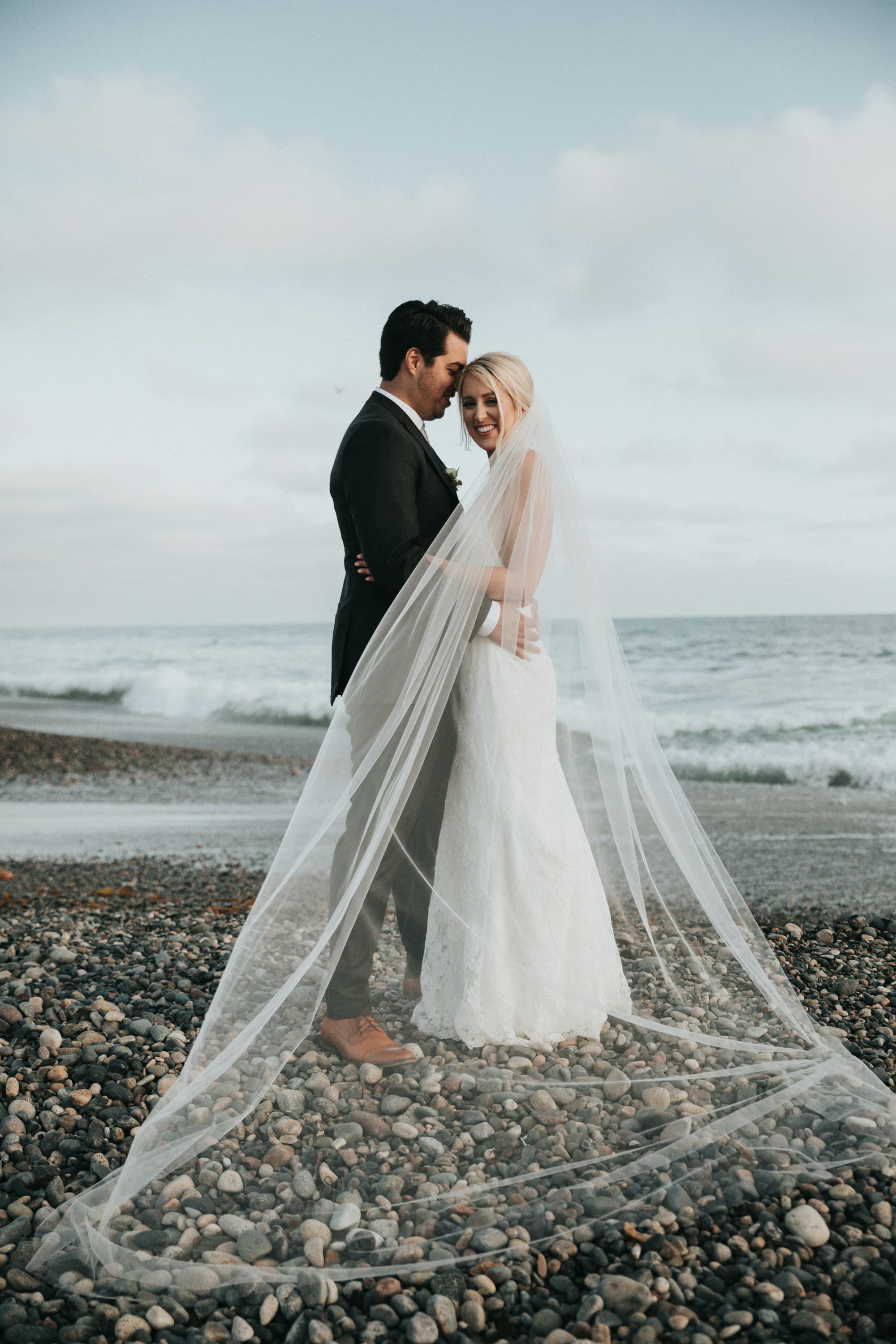 Bride and groom on a pebble beach at a destination wedding