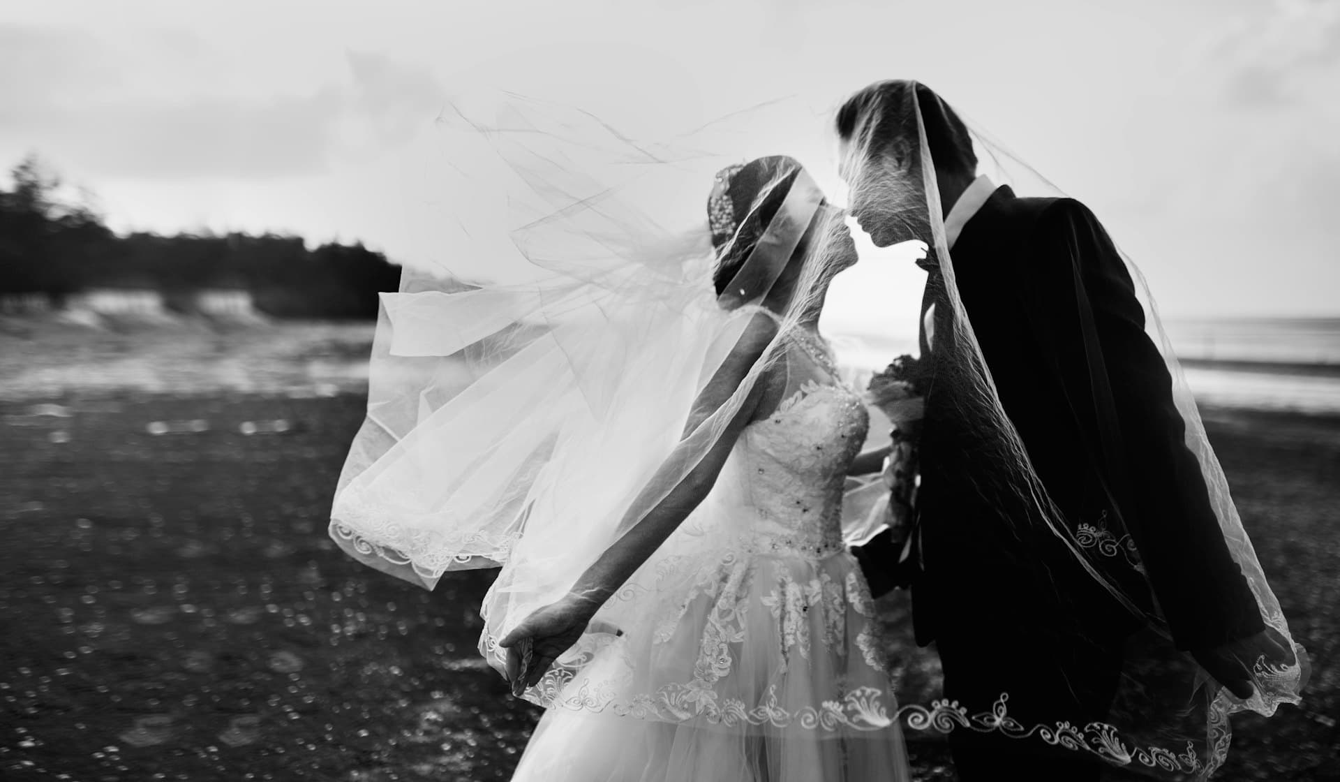Intimate Western bride and groom wrapped in a flowing veil