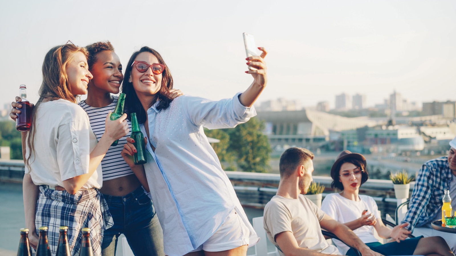 Friends taking a playful selfie at a rooftop party