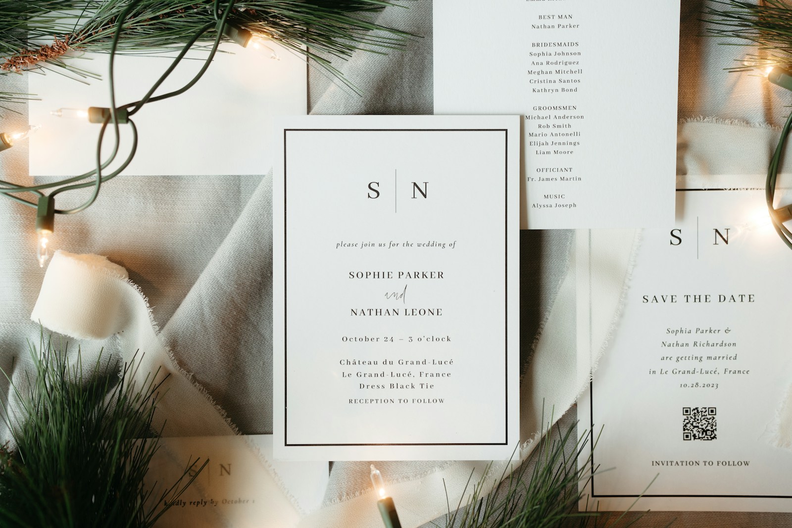 Elegant wedding invitations styled with greenery and lights