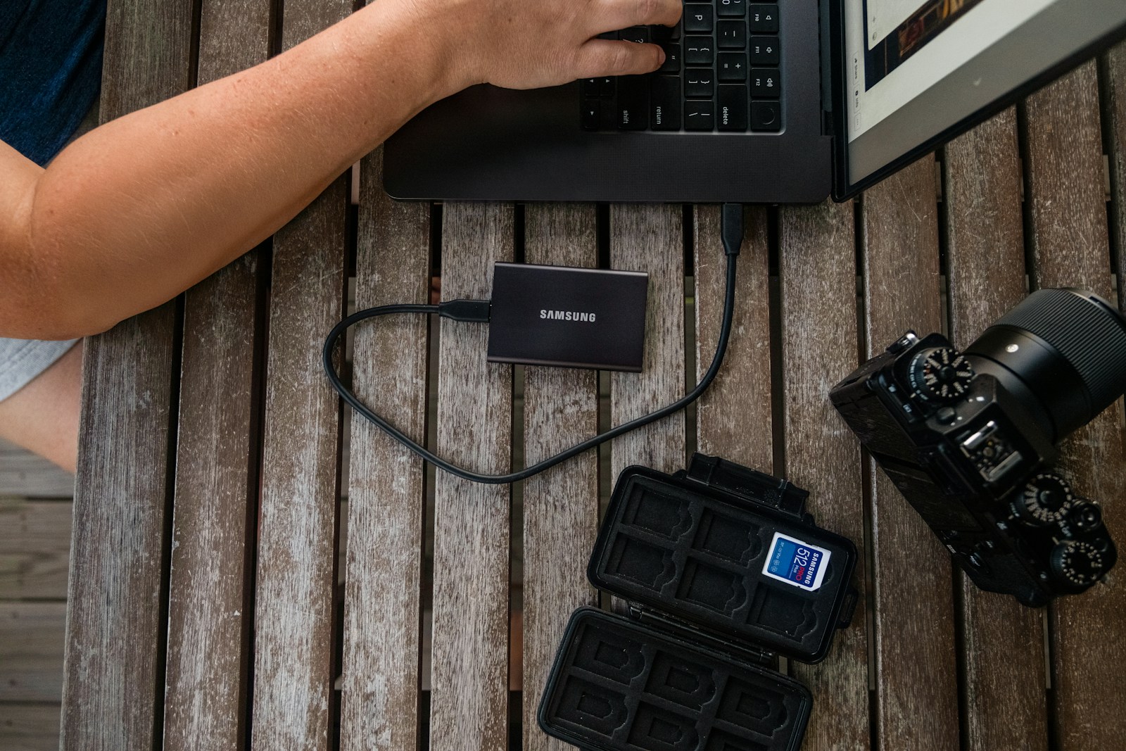 A photographer backing up files from a camera to an external drive