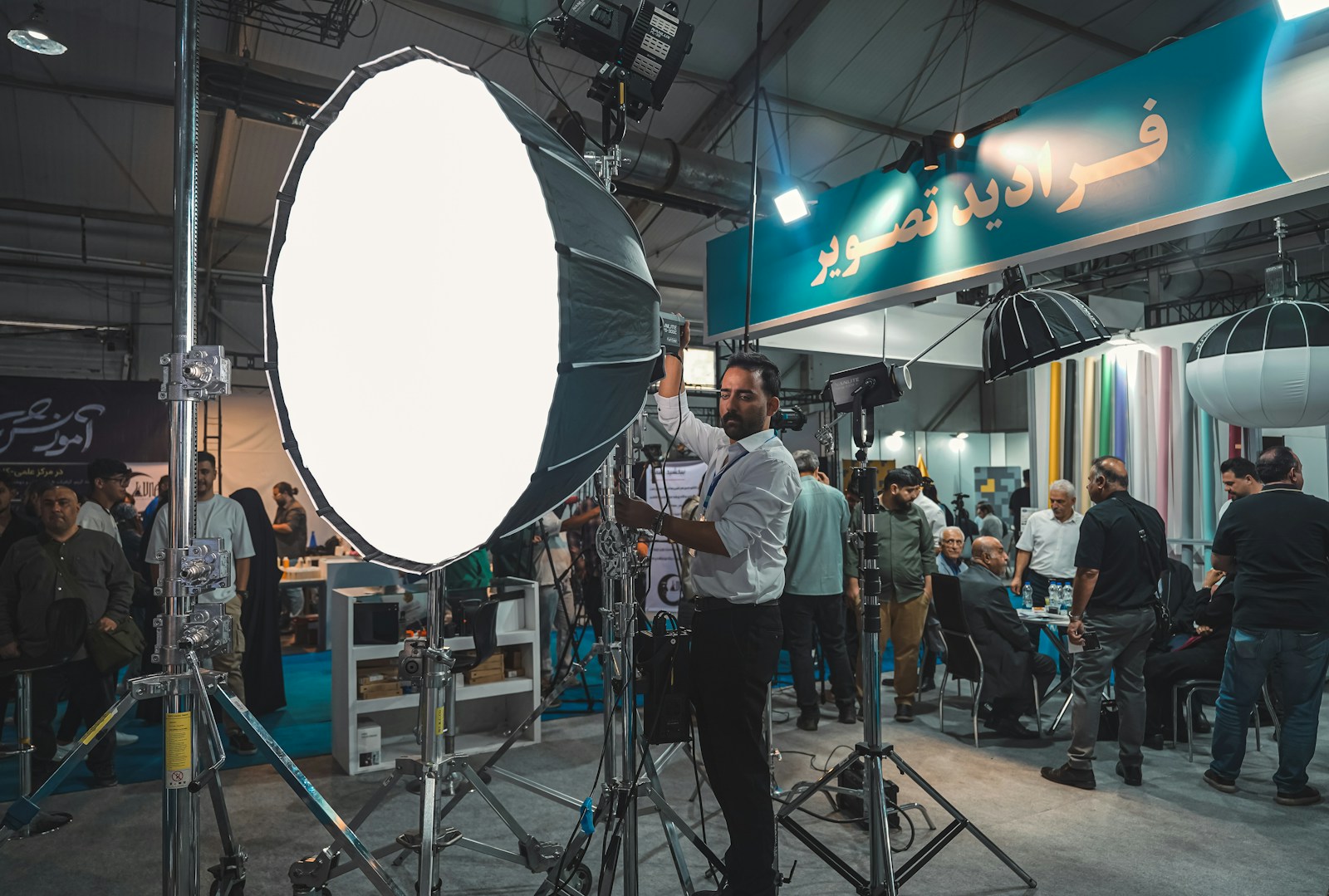 A photographer adjusting large studio lighting equipment
