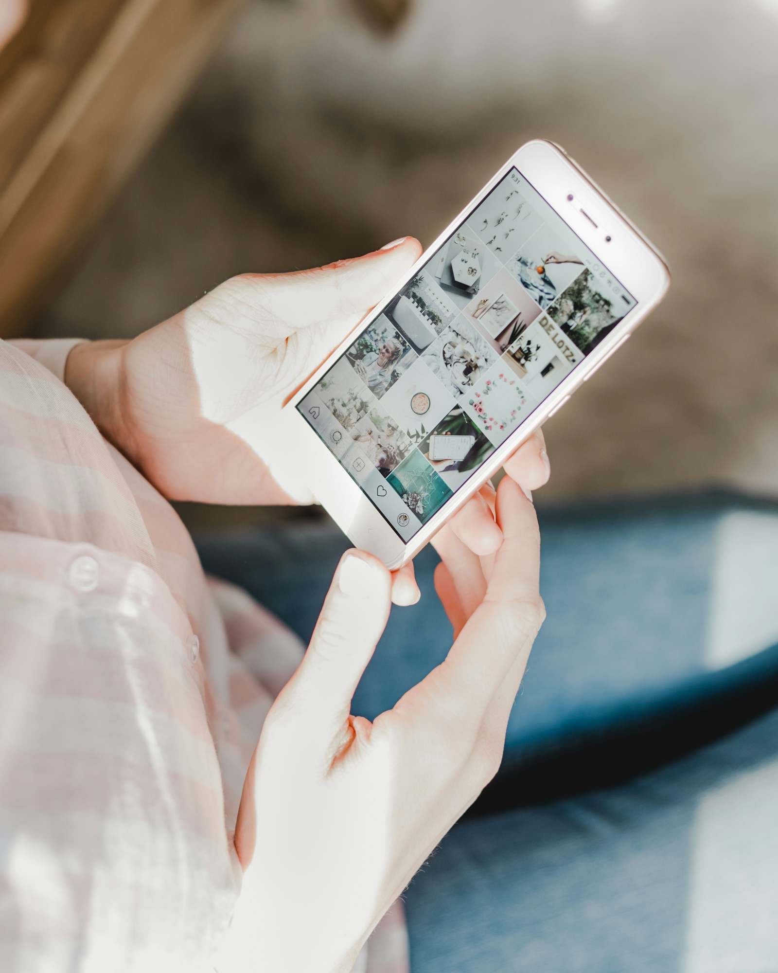 A photographer holding a smartphone with a visual social feed