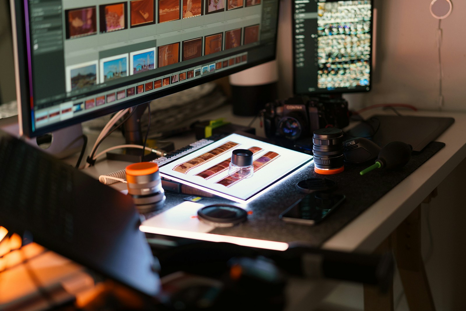 A photographer workspace with computers and camera equipment