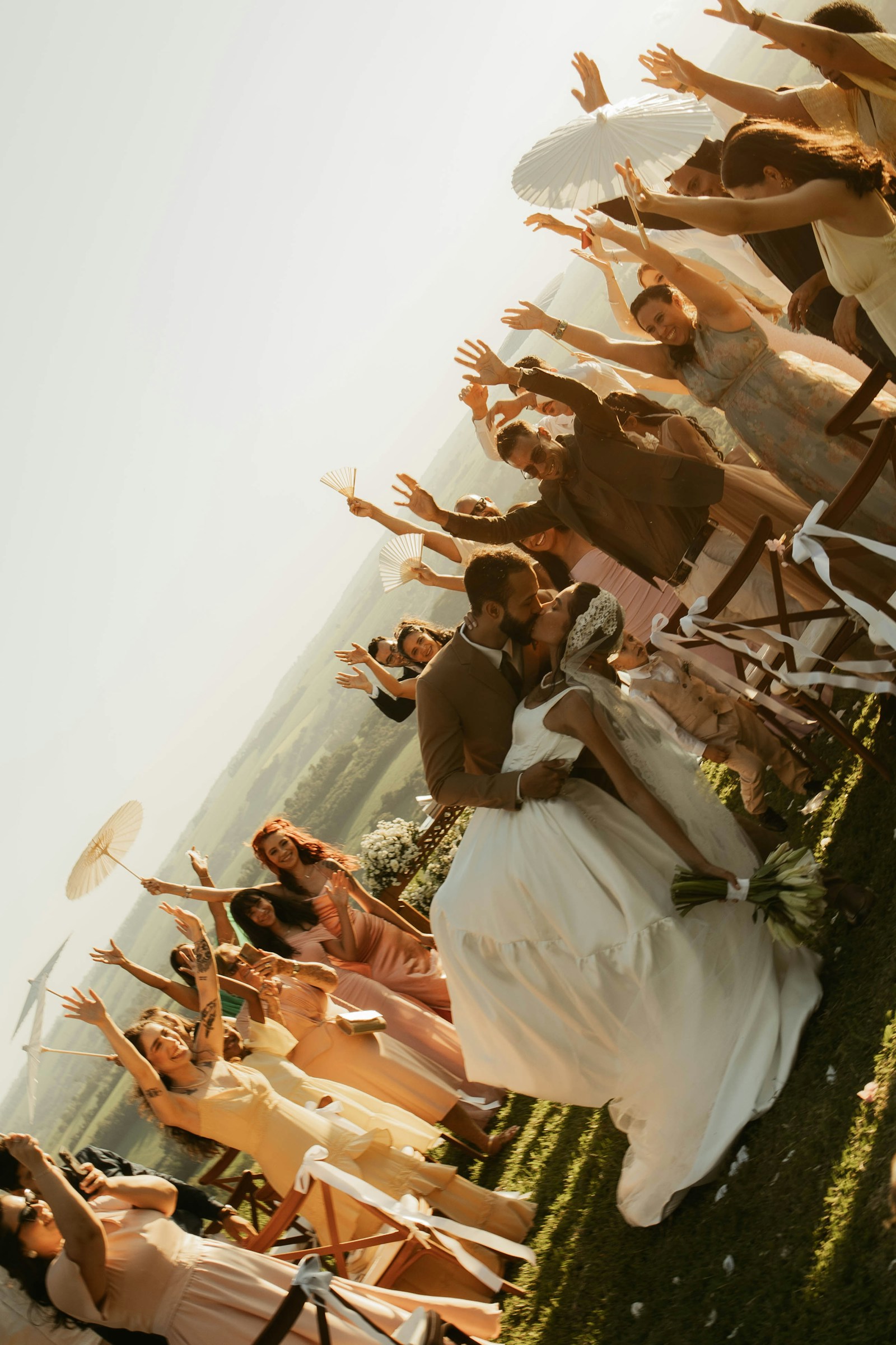 A newly married couple celebrating as guests cheer