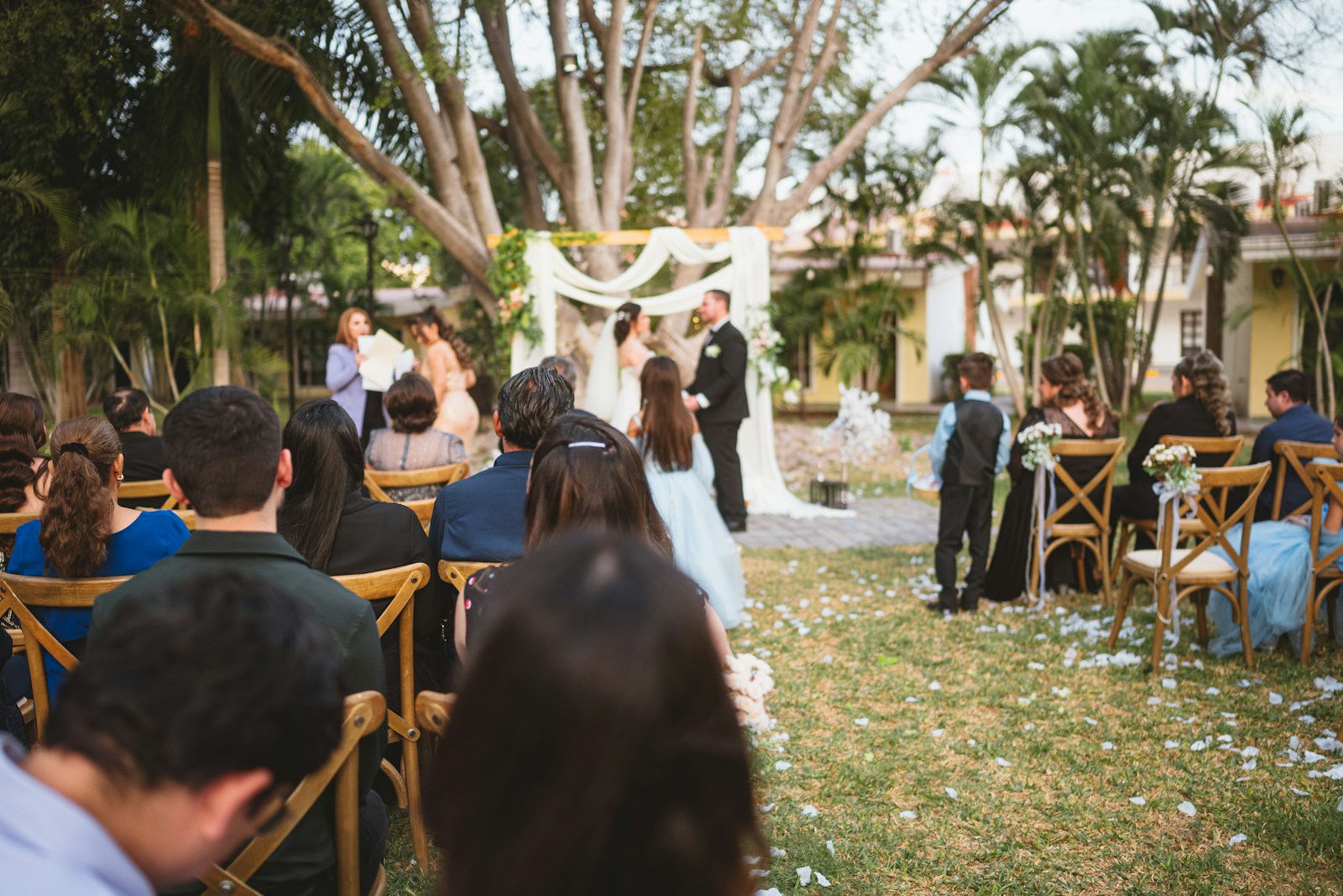 An outdoor wedding ceremony surrounded by guests
