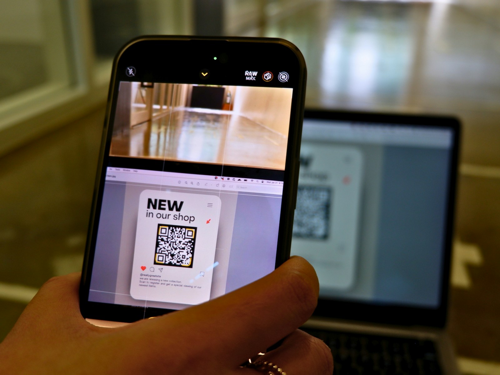 A guest using a phone beside a laptop to access a shared gallery